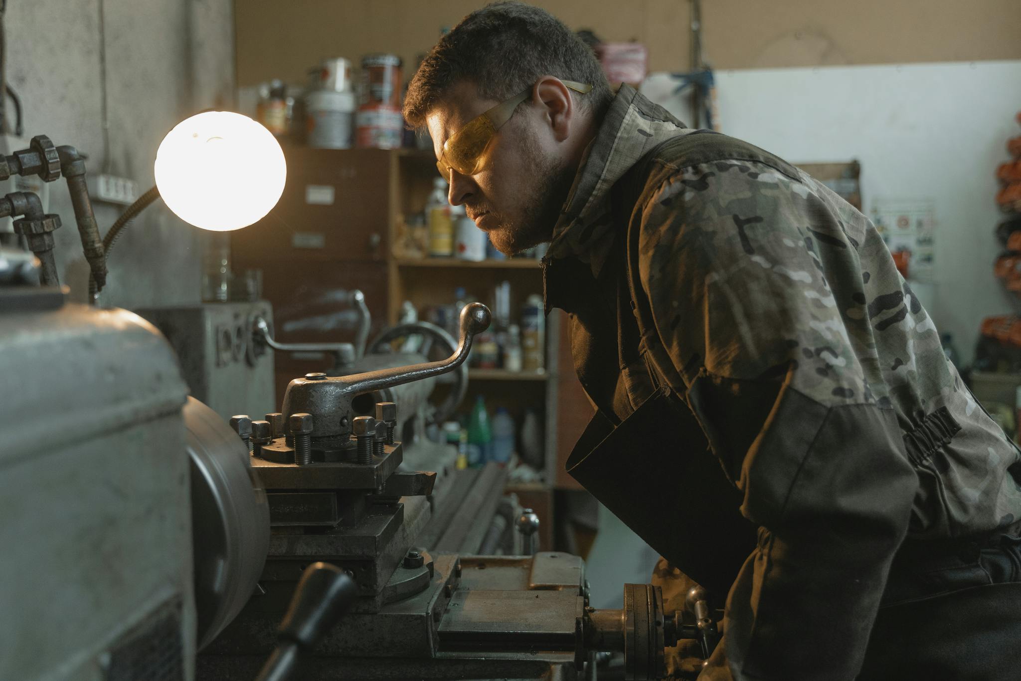 Focused craftsman using a lathe machine in an industrial setting.